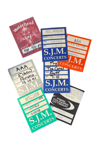 A white background with a bunch of tickets sitting on top of each other. The tickets have text written on them, likely indicating the dates and times of the concert.